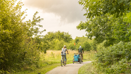 Image of two people riding a bike.